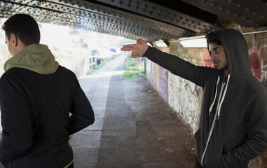 man making threatening gesture of a gun to other man